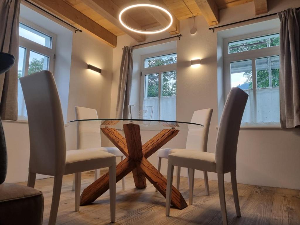 uma sala de jantar com uma mesa de vidro e cadeiras em Appartamento Vale e Schena Cortina D'Ampezzo em San Vito di Cadore