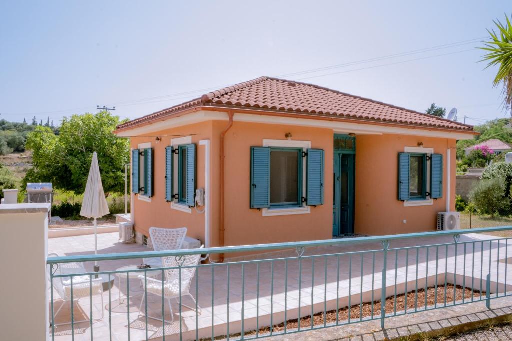 a small orange house with a fence in front of it at Abuelita Cottage in Andipáta Erísou