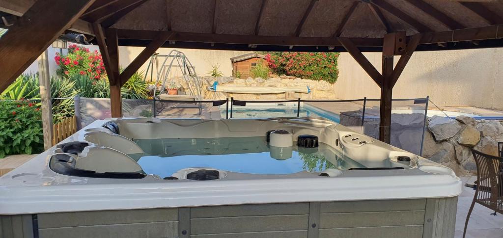 een bad onder een prieel bij POOL HOUSE AVEC PISCINE ET SPA - RESIDENCE PRIVEE in Milhaud