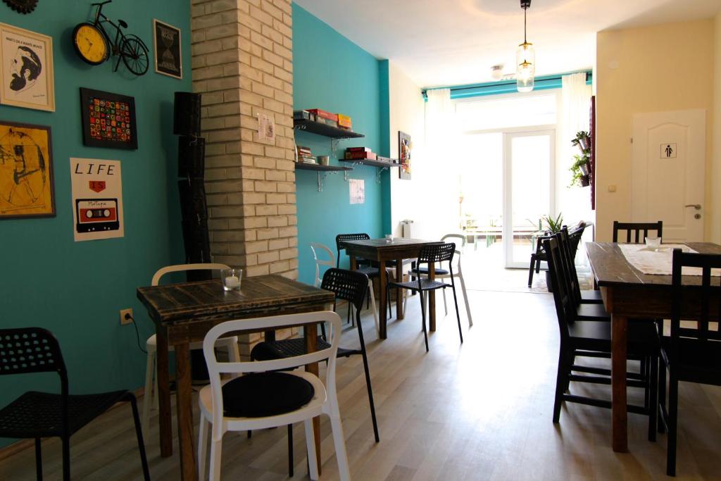 comedor con mesas y sillas y paredes azules en Falling Lakes Hostel en Korenica