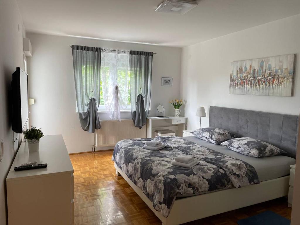 - une chambre avec un grand lit et une fenêtre dans l'établissement DIS apartment Varaždin, à Varaždin