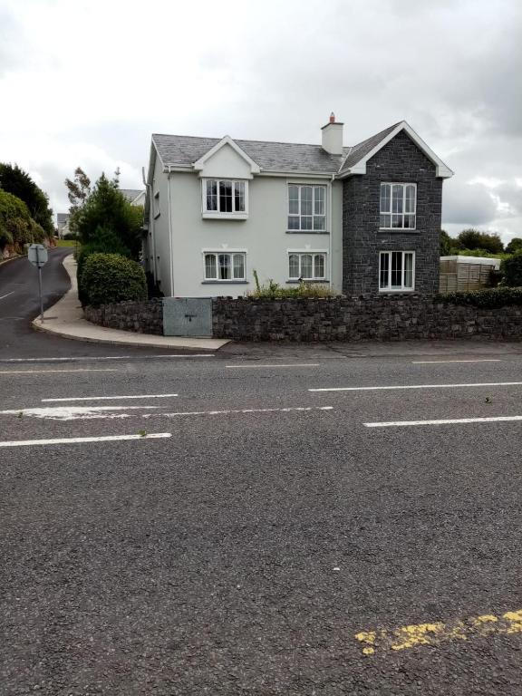 una casa blanca al lado de una carretera en Parnell house en Ennis