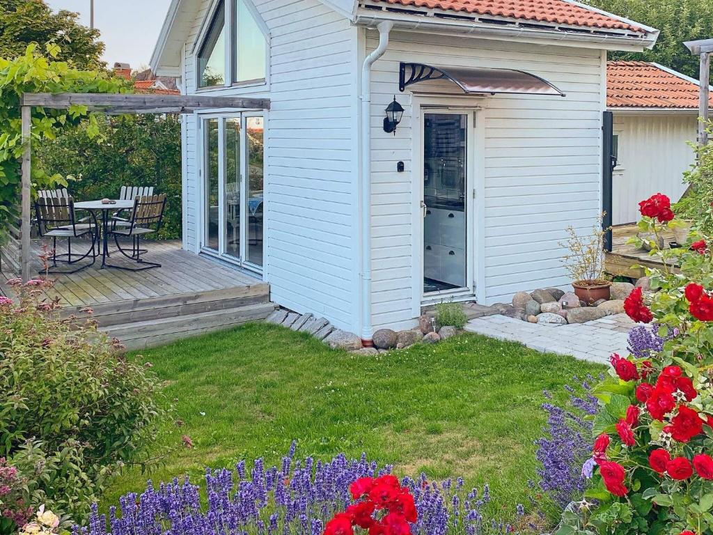 Cette petite maison blanche dispose d'une table et d'une terrasse. dans l'établissement Holiday home HUNNEBOSTRAND XI, à Hunnebostrand