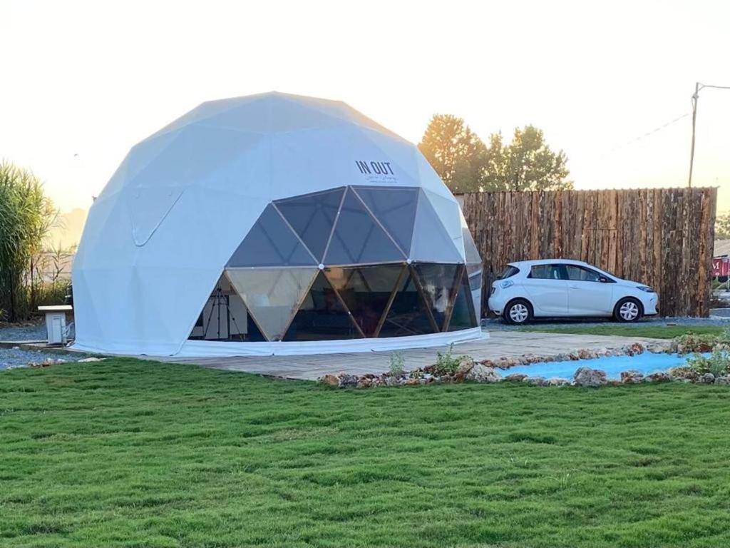アンタルヤにあるIn out superior glampingの車を乗り入れた庭に座る大型テント