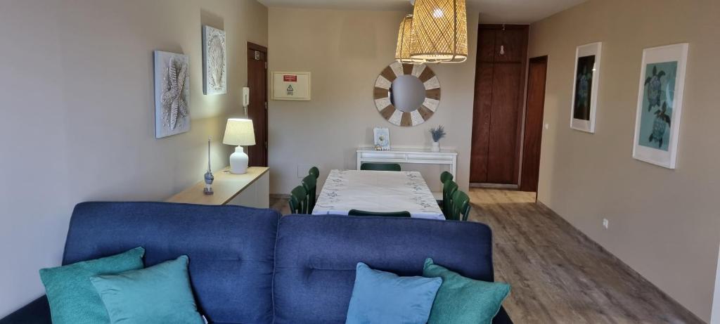 a living room with a blue couch and a table at Marear in Porto Santo