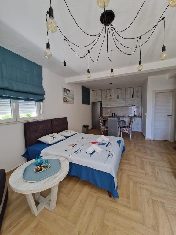 a bedroom with a bed and a table in it at Studio apartman Happy Home in Tivat