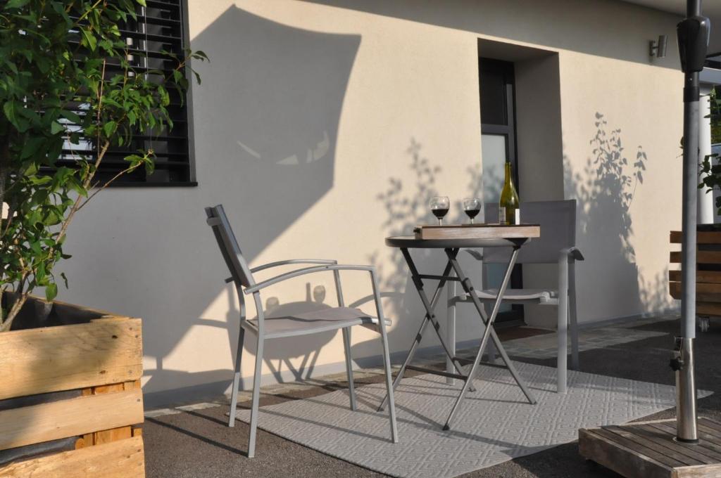 een tafel en een stoel en een tafel met wijnglazen bij l'adret in Villaz