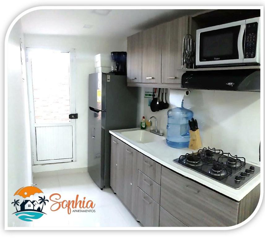 uma pequena cozinha com fogão e micro-ondas em Apartamentos sophia em San Andrés