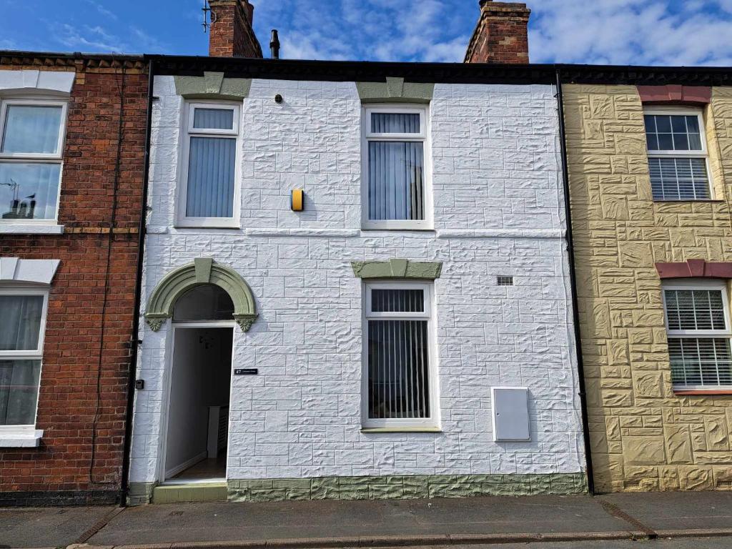 a white building with windows and a door at Immaculate 2-Bed Cottage - Free WiFi in Bridlington