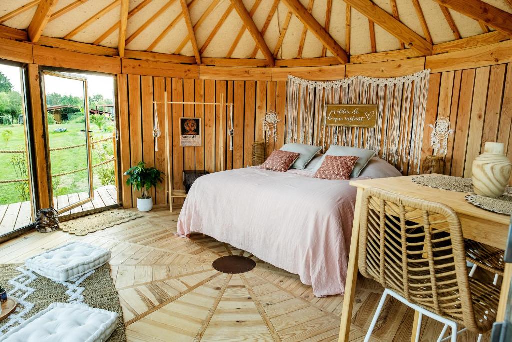 um quarto com uma cama num quarto com paredes de madeira em La Belle Ronde 