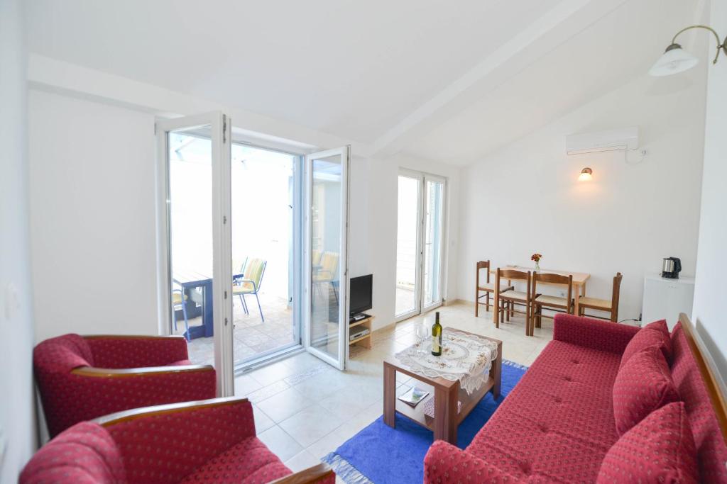 un soggiorno con 2 sedie rosse e un tavolo di Apartment's Belvedere a Kotor (Cattaro)