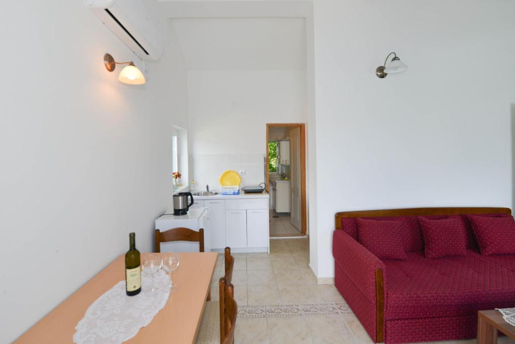 uma sala de estar com um sofá vermelho e uma mesa em Apartment's Belvedere em Kotor