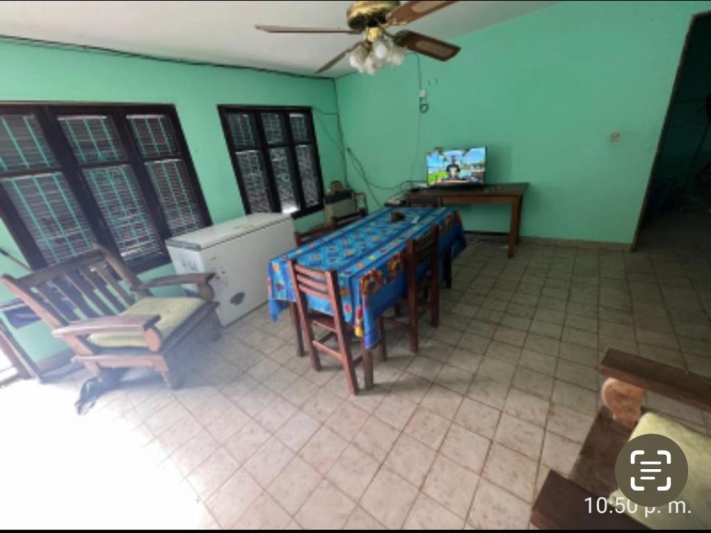 sala de estar con mesa, sillas y ventilador de techo en La roka gym casa, en San Salvador de Jujuy