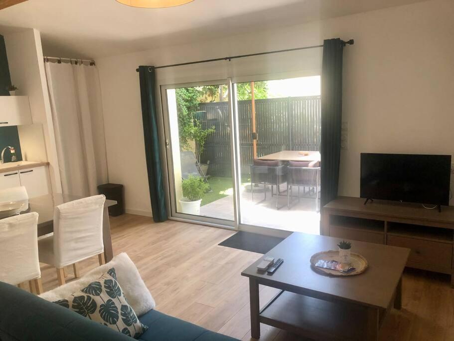 a living room with a couch and a table at Gîte du centre- Maison avec extérieur en centre ville in Mèze