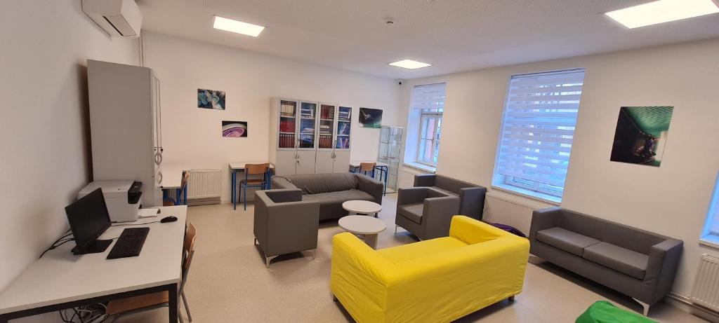 a living room with a yellow chair and a desk at Zagreb budget rooms in Zagreb