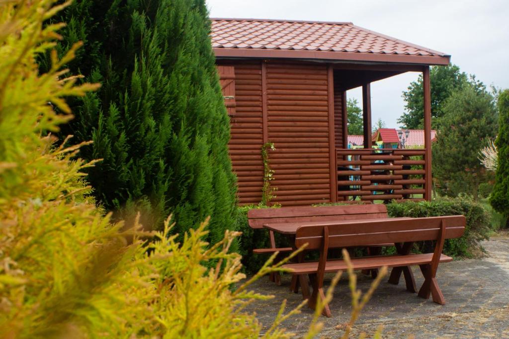 Cabaña de madera con mesa de picnic y banco en Domki u Bukowskich en Jezierzany