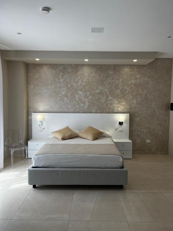 um quarto com uma cama grande e uma parede em B&B VIRGILIO LAMEZIA AIRPORT em SantʼEufemia Lamezia