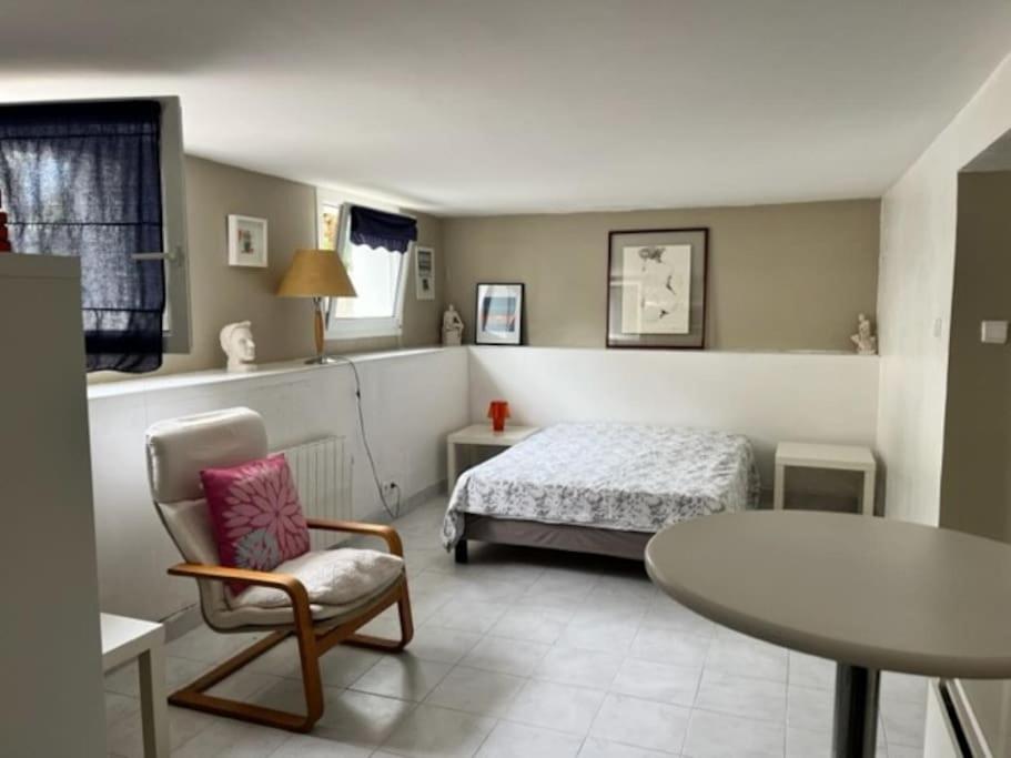 ein Schlafzimmer mit einem Bett, einem Tisch und einem Stuhl in der Unterkunft Maison à Chiberta, à 5 minutes à pieds des plages in Anglet