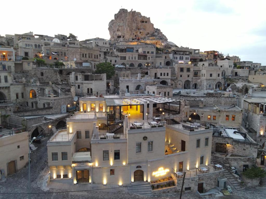 uma vista para uma cidade com uma montanha em Kappadoks Cave Hotel em Üçhisar