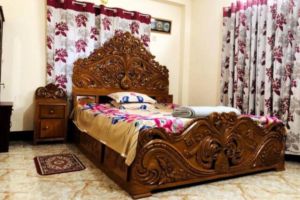 a bed with an ornate wooden frame in a bedroom at Modern 3 Bedroom Flat in Sylhet in Sylhet