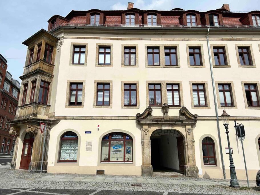 un grand bâtiment blanc avec une arche devant lui dans l'établissement FeWos Anno 1529 in Top-Altstadtlage von Zittau, à Zittau