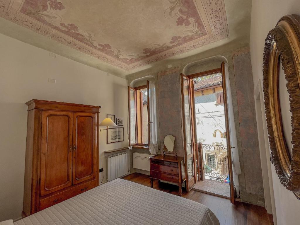 a bedroom with a bed and a dresser and a window at Appartamento al Teatro Romano in Verona
