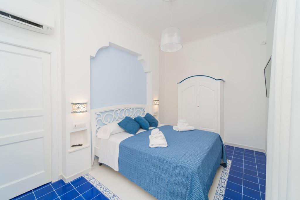 una camera da letto con un letto blu e bianco e piastrelle blu di Relais Capitolo a Maiori