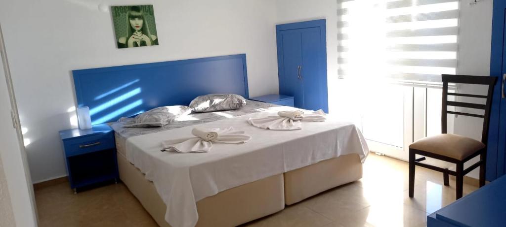 a blue bedroom with a bed and a chair at Вилла in Belek