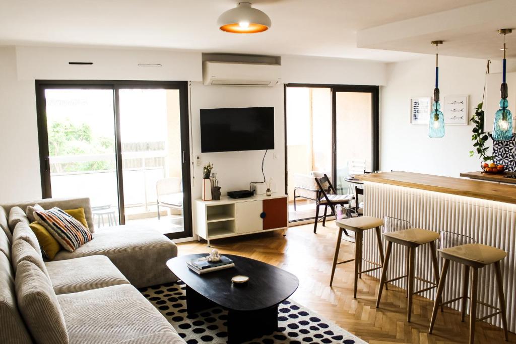 un soggiorno con divano e tavolo di Charment appartement à Marseille - Prado A/C a Marsiglia