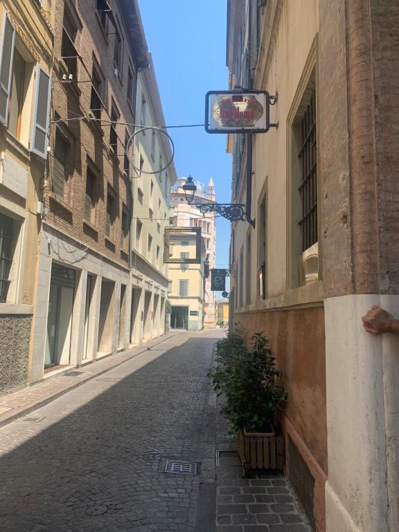 um beco vazio com uma planta ao lado de um edifício em residenza Al Duomo em Parma