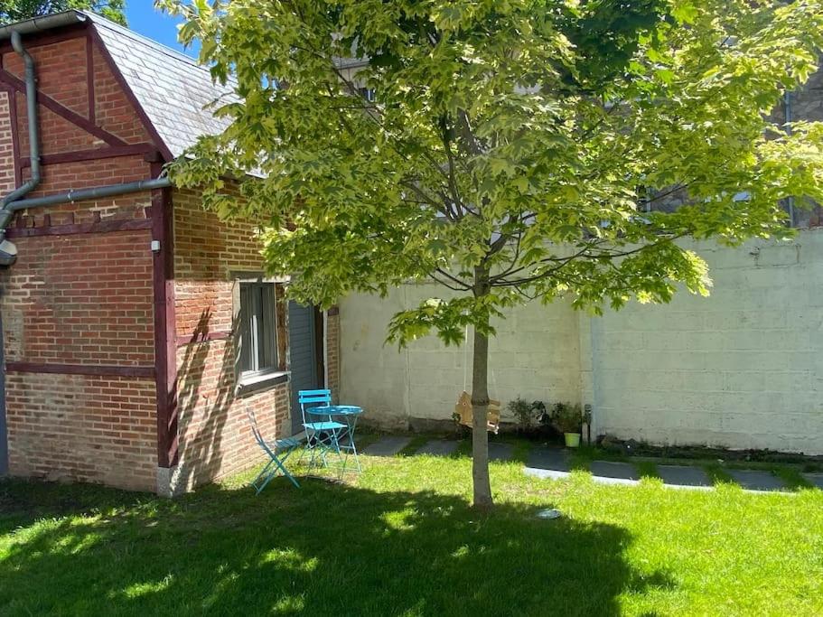 una casa con un albero e una sedia nel cortile di La petite maison du Thabor a Rennes
