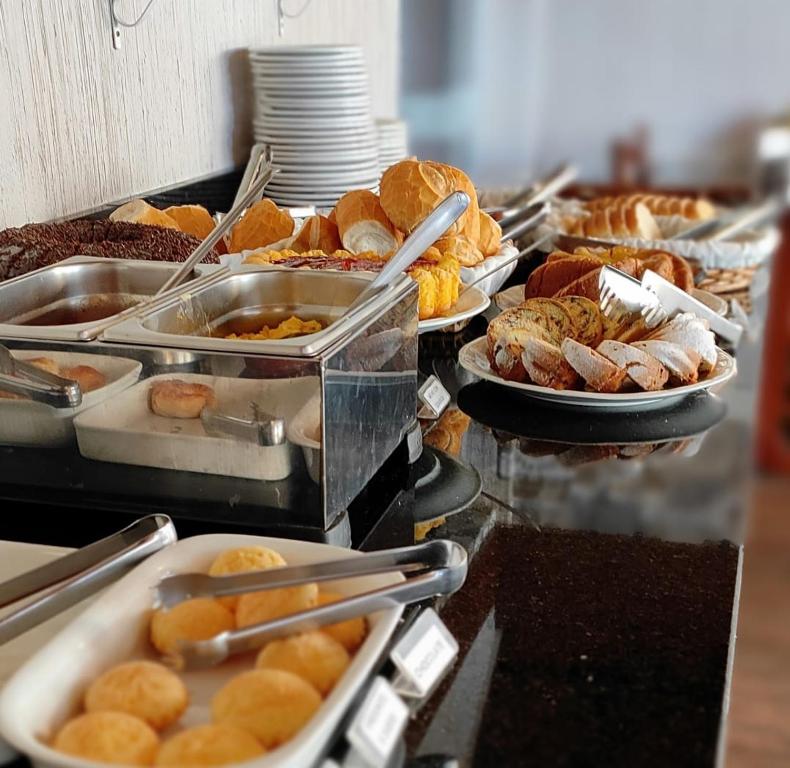 una línea de buffet con muchos tipos diferentes de comida en Hotel Cabana Jardim de Flores, en Gramado