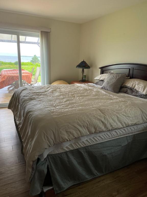 a bedroom with a large bed with a large window at Lica’s house in Vernon Bridge