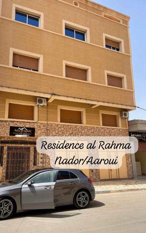 un coche aparcado frente a un edificio en Residence al Rahma 05 en Monte ʼArrouit