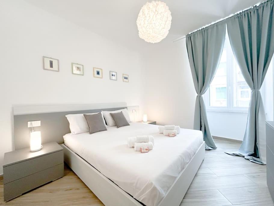a white bedroom with a large bed and a window at [Lusso in Centro Storico] - WIFI - AC in Savona