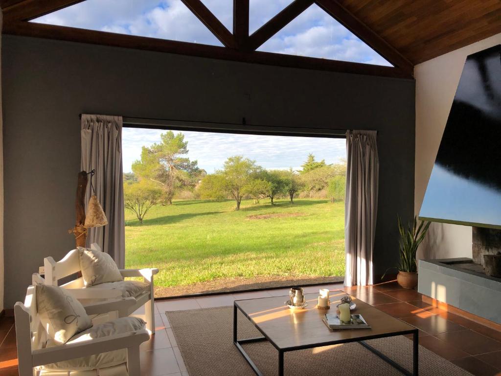 una sala de estar con una gran ventana con vistas a un campo en La Recompensa House 