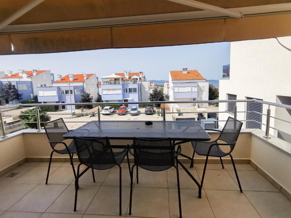 a table and chairs on a balcony with a view at Apartman Luka in Zadar