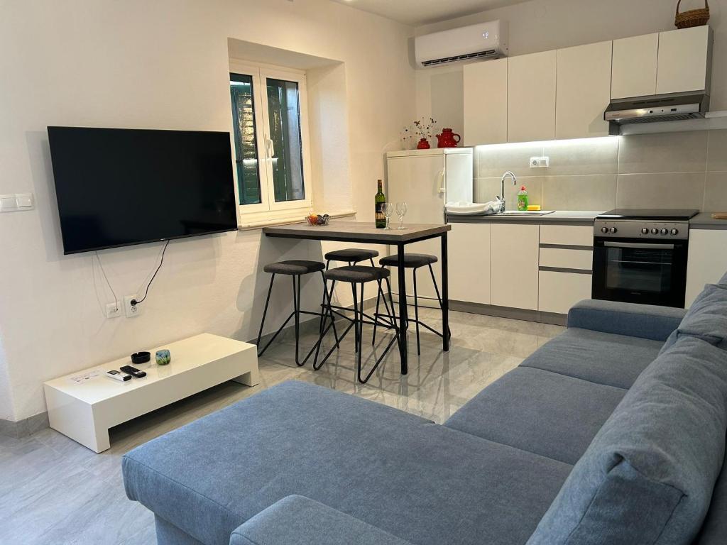 ein Wohnzimmer mit einem Sofa und einem Tisch sowie eine Küche in der Unterkunft Holiday house Misetic in Selca