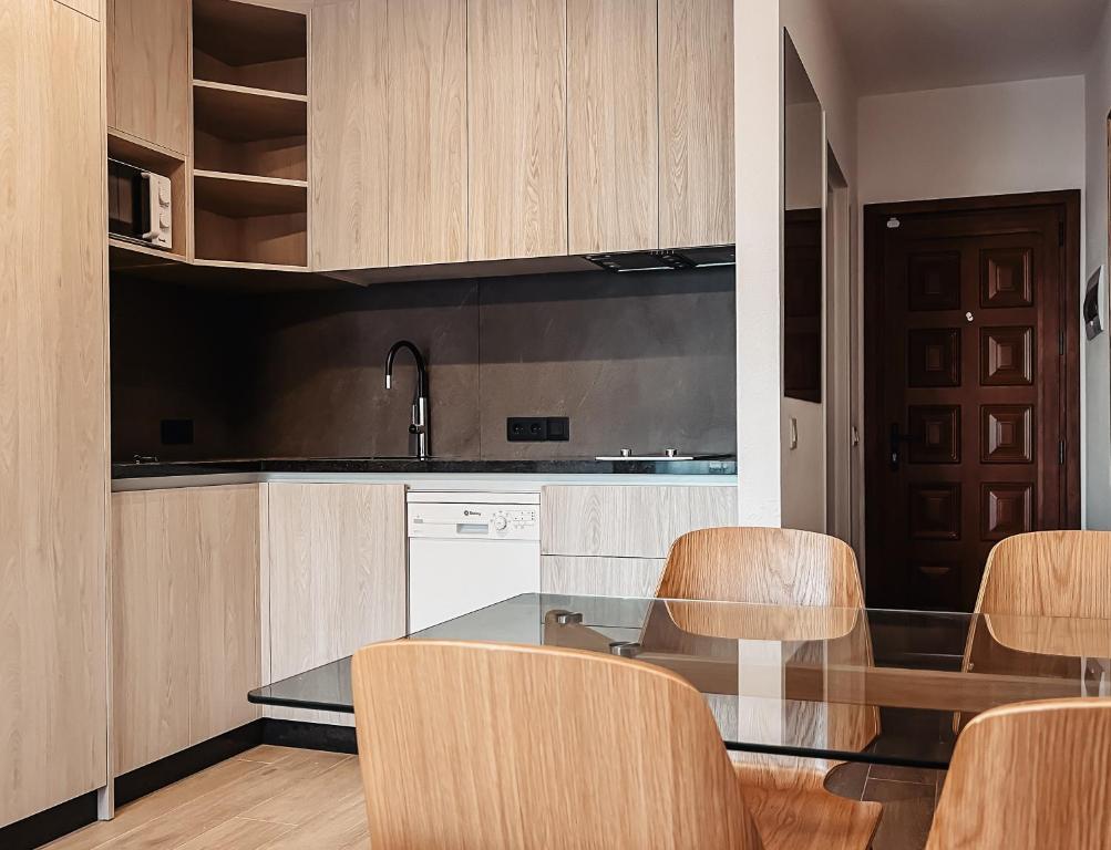 a kitchen with wooden cabinets and a table and chairs at Sapphire Riviera Residence in Adeje