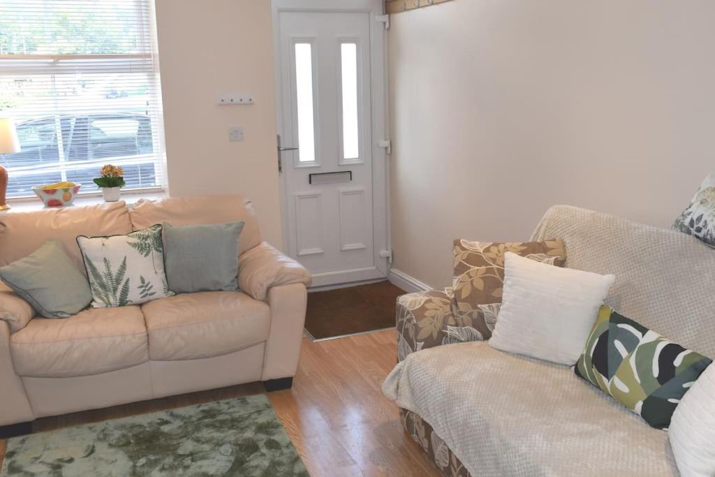 a living room with a couch and a chair at Hill View Cottage in Bala
