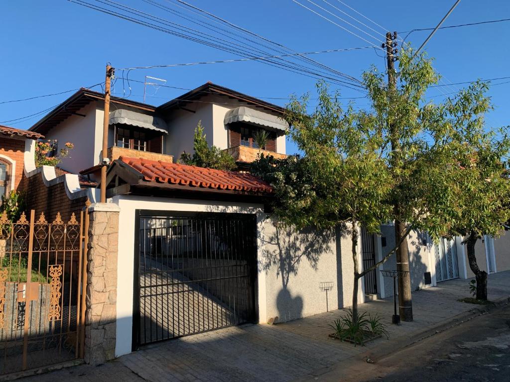 a white house with a gate in front of it at Hospedaria Canto do Vinhedo in Espirito Santo Do Pinhal