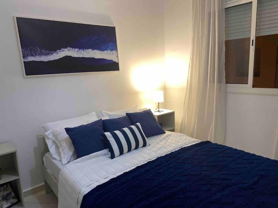 een slaapkamer met een bed met blauwe en witte kussens bij joy house +équipement de plage(chaises et parasol) in Martil