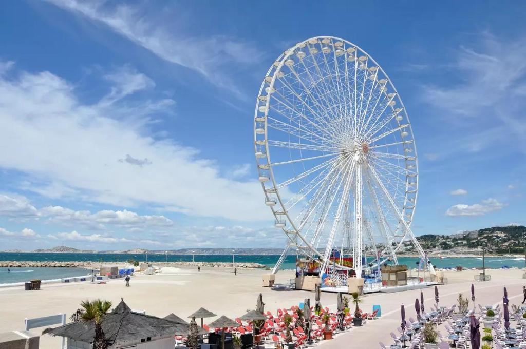 une grande roue sur une plage avec une foule de gens dans l'établissement Appartement au bor de mer, à Marseille