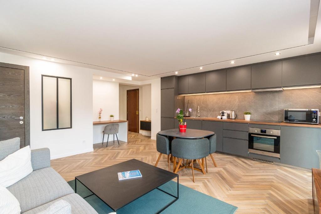 une cuisine et un salon avec un canapé et une table dans l'établissement Heart of Cannes contemporary 2BR garden view Palais & Croisette 5 mn by Olam Properties, à Cannes