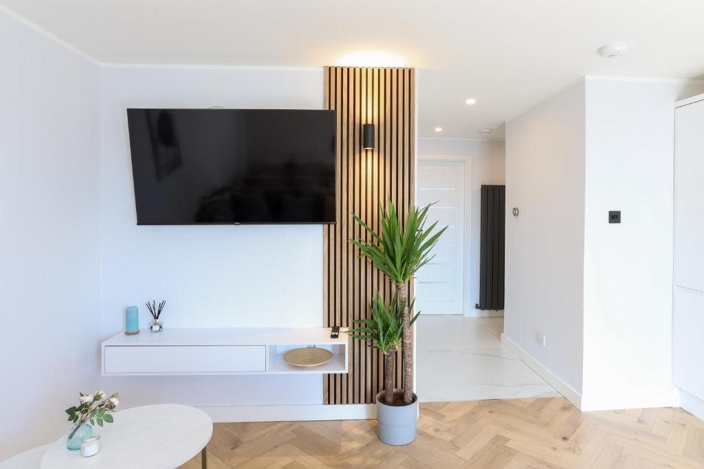 a living room with a tv on a wall at Luxurious City Centre Apartment in Perth
