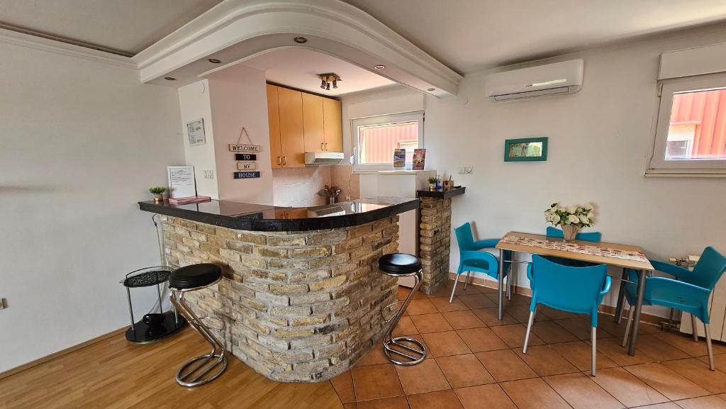 a kitchen with a bar and a table and chairs at City Center Luxury Apartment in Subotica