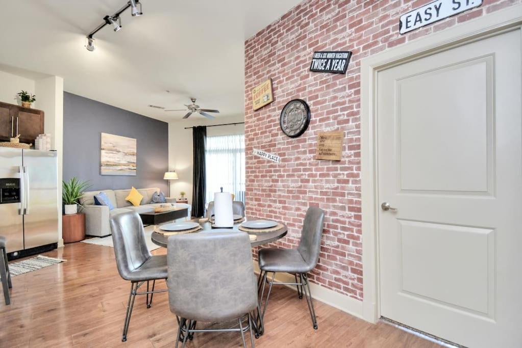 a room with a brick wall and a table and chairs at Lux Mid-Rise Walking Distance to NRG Stadium in Houston