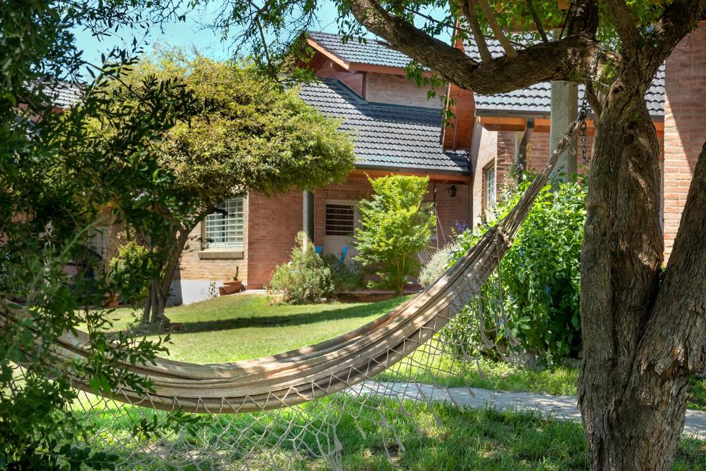 - un hamac en face d'une maison dans l'établissement Casa Arboles De Tala con parque amplio, à Villa General Belgrano