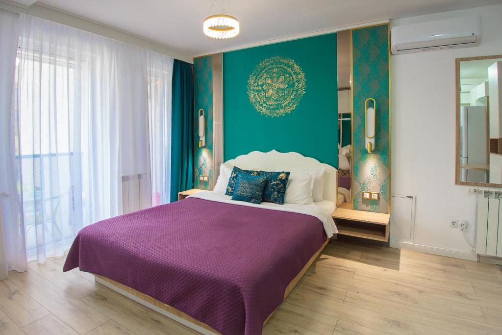 a bedroom with a large bed with a purple blanket at Gold Class Apartments AMS in Cluj-Napoca