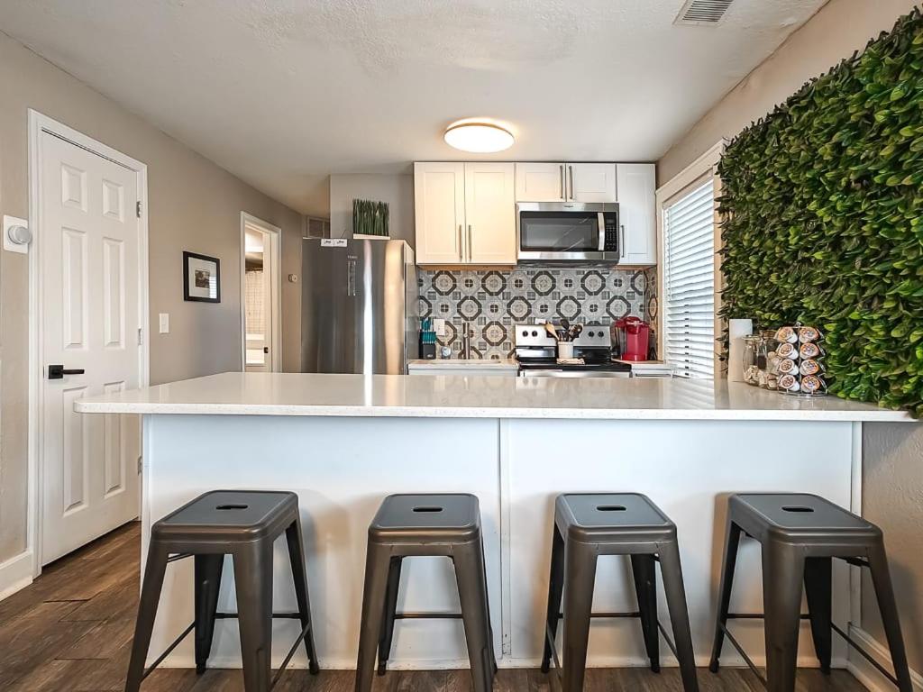 a kitchen with a counter with three stools at Heart of Westport 1BR in Kansas City